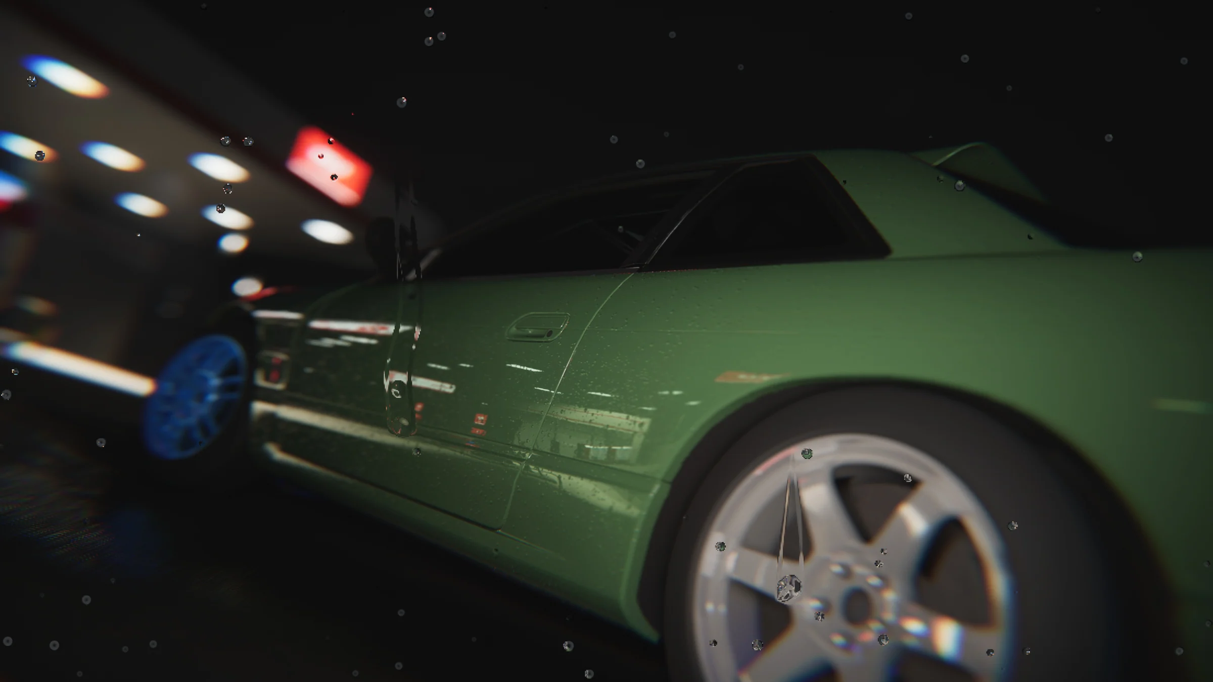 Close side view of a green coupe with silver rear wheels under the fuel station canopy at night