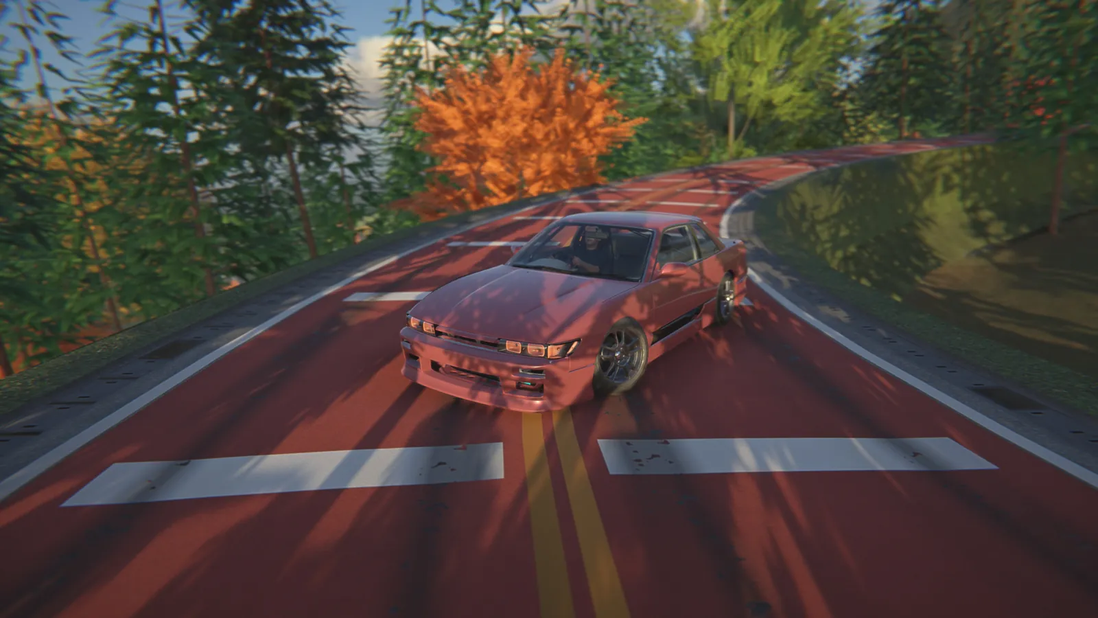 Red coupe on a curving road with white crossing lines in an autumn forest