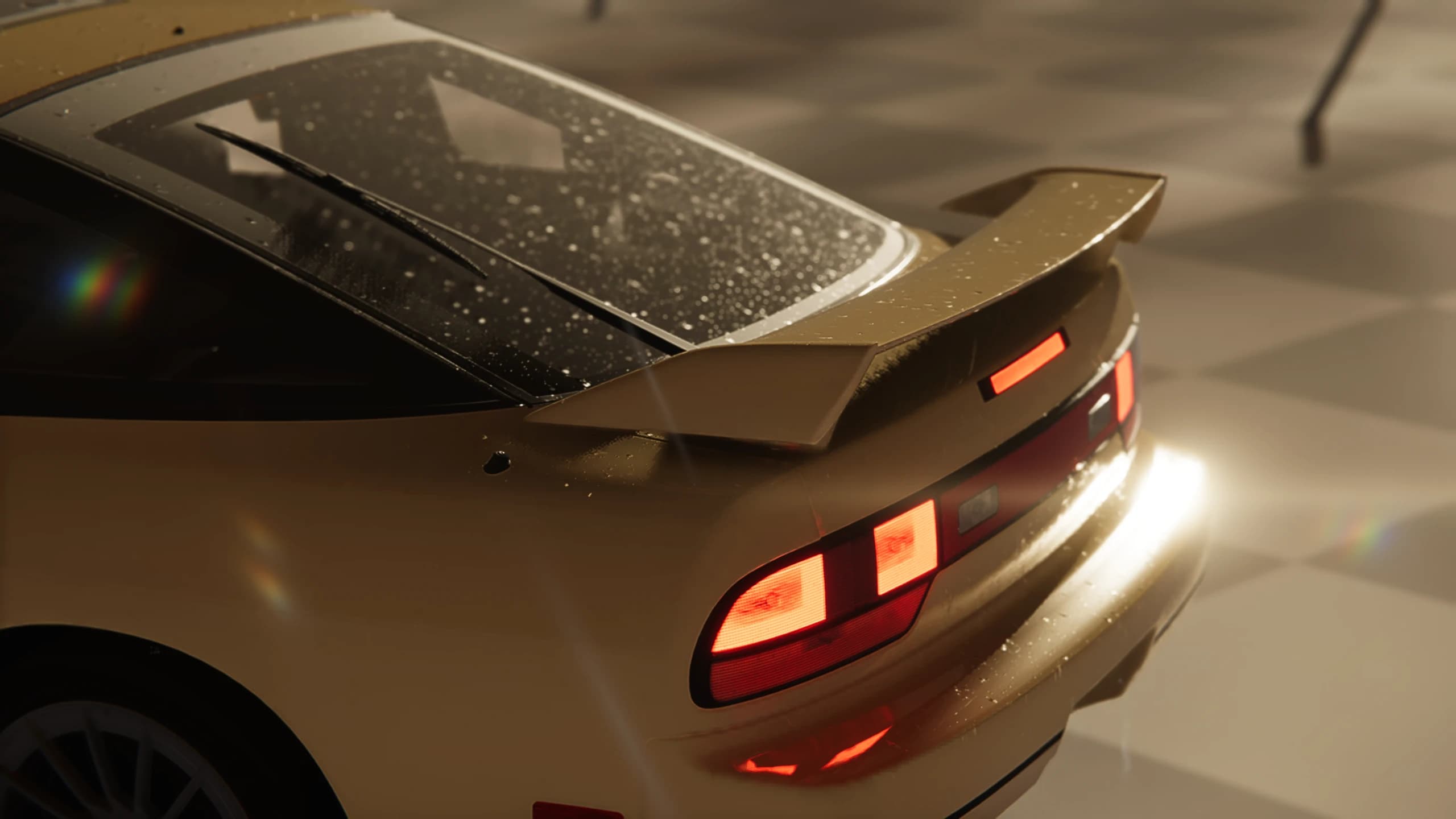 Wet rear window, spoiler and tail lights under warm lighting