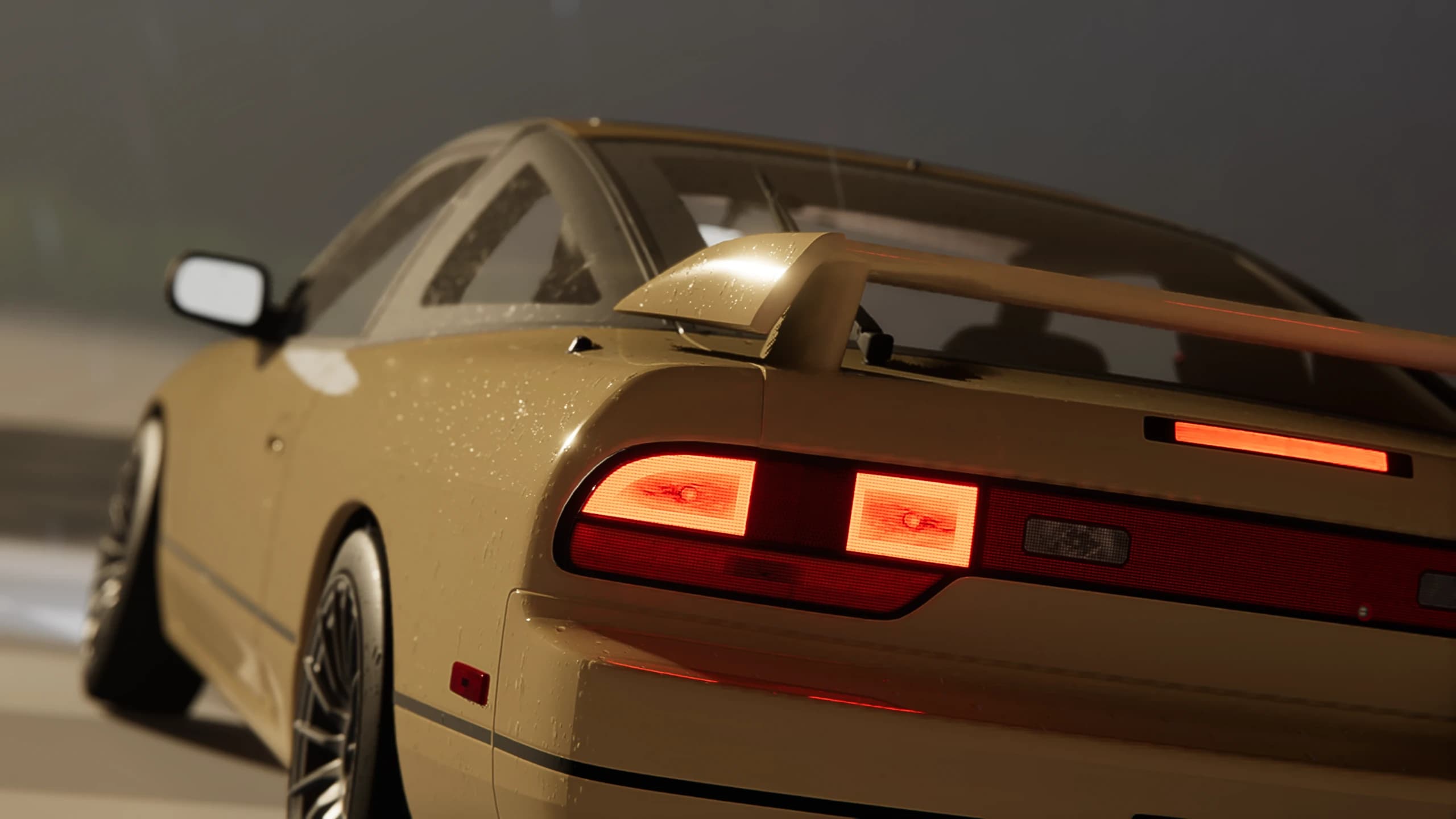 Rain-covered rear quarter and illuminated tail lights of a coupe