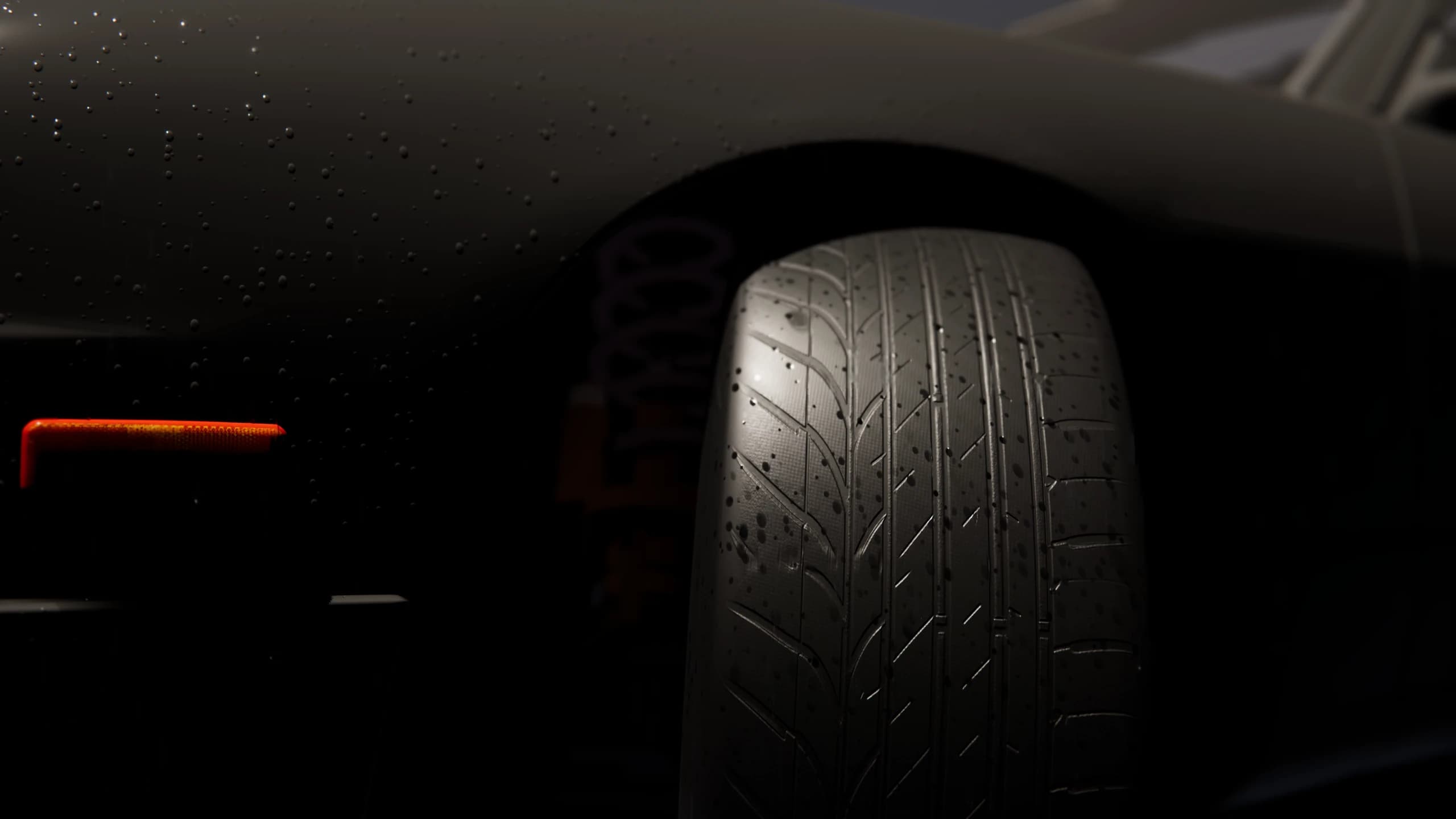 Close view of wet tyre tread and water droplets on the bodywork