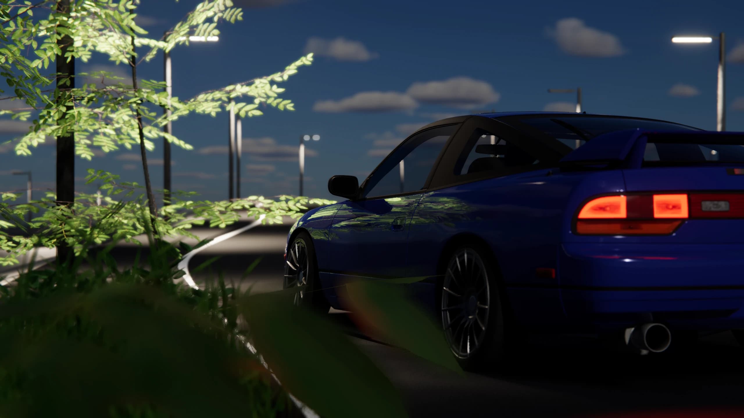 Blue coupe seen through roadside foliage beneath street lights