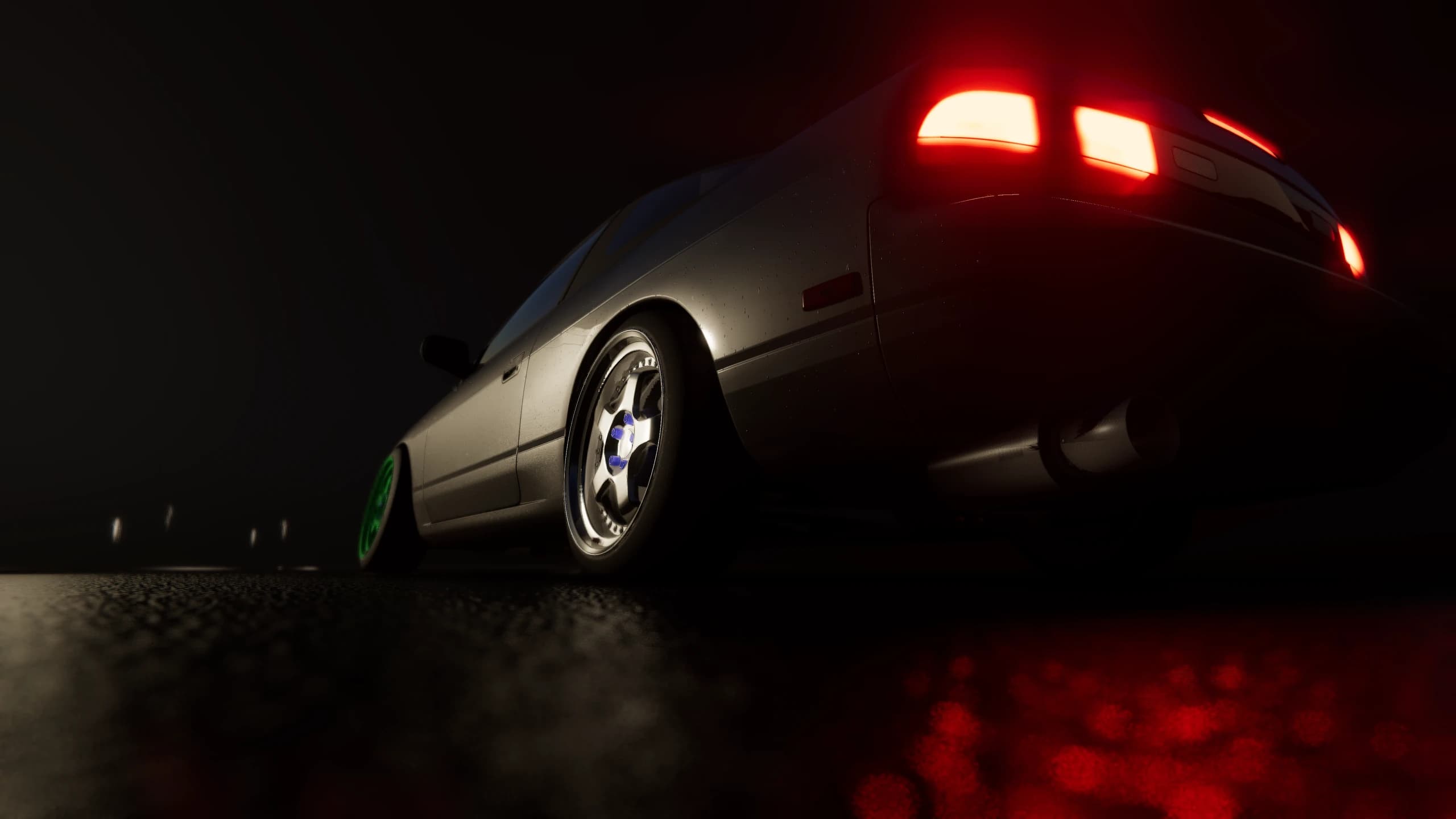 Low rear view of a coupe reflected in a rain-soaked road