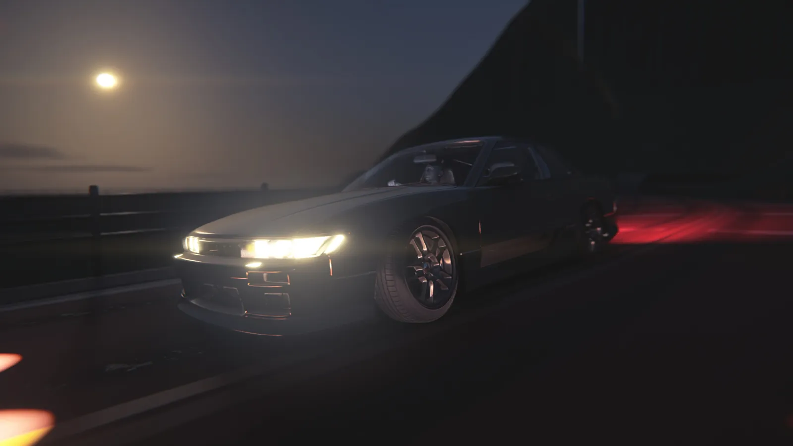 Front-quarter view of a coupe with its headlights on beside a guardrail, with a pale moon over the water in the background